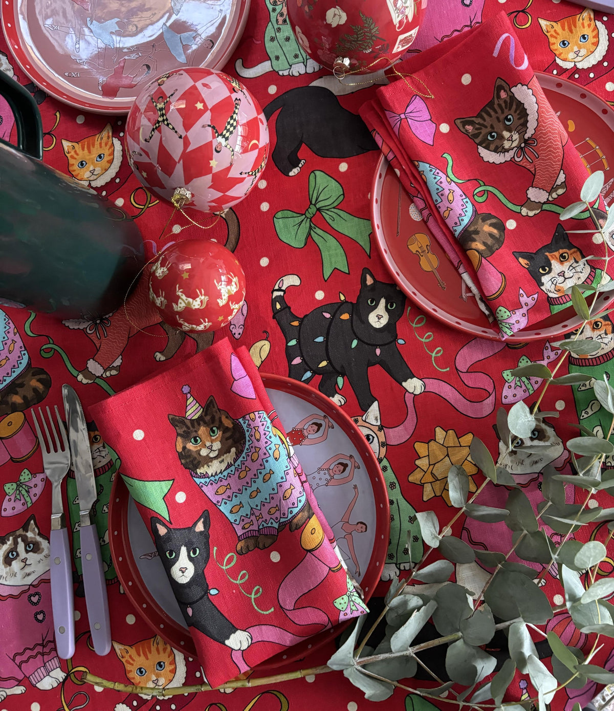 Cats' Christmas Morning napkins laid on the matching tablecloth