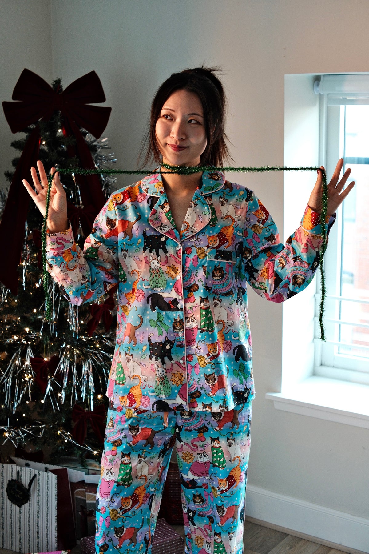 Cats' Christmas Morning rainbow pyjamas by the Christmas tree