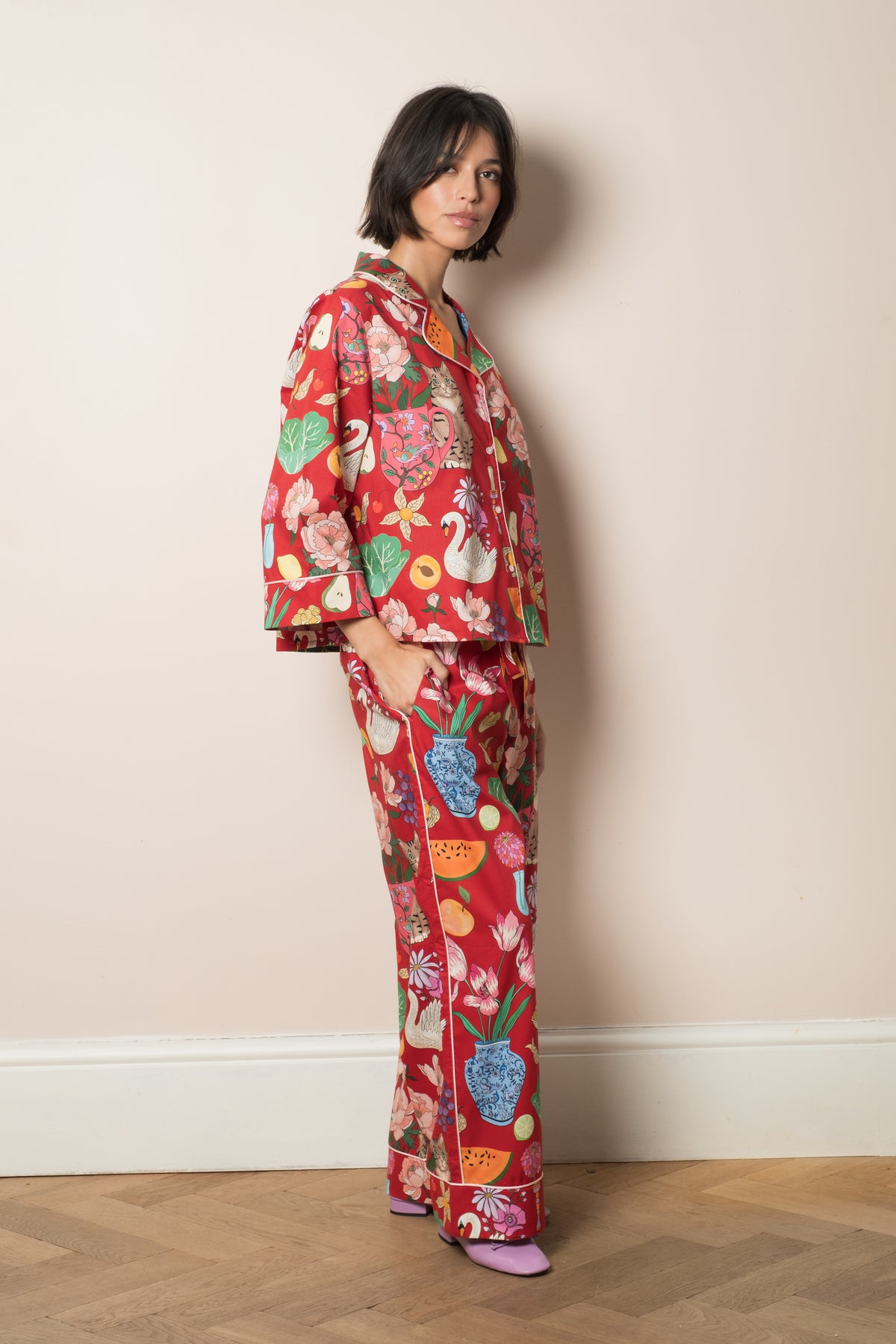 Burgundy Tabletop pyjama set shown from the back, still life print of blue and white vases, fruit and flowers