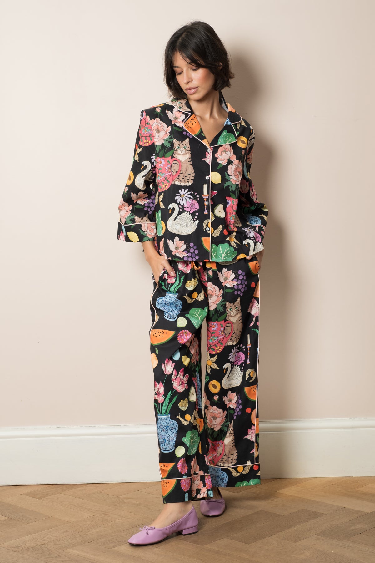 Tabletop organic cotton pyjama set in midnight black, hand-illustrated still life print of swans, peonies and a cat in a jug